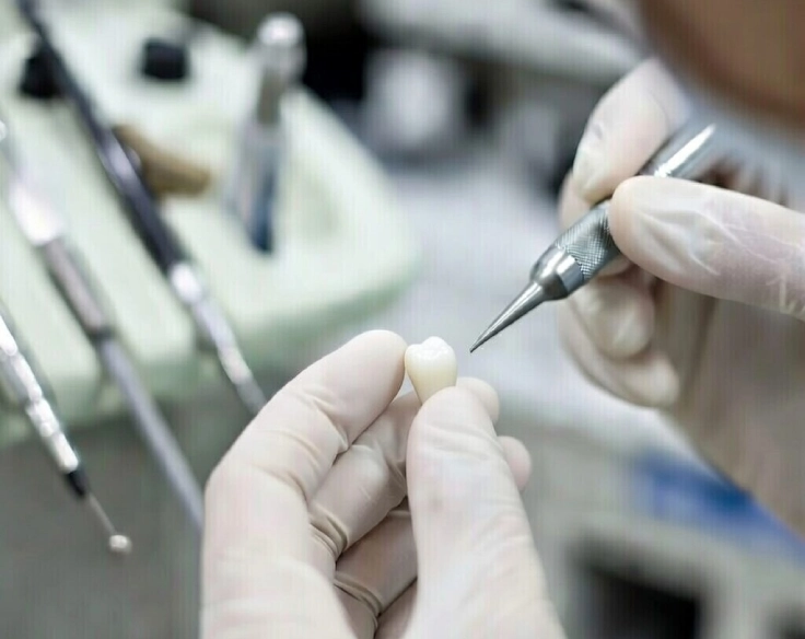 Зубной мастер создает коронку на зуб