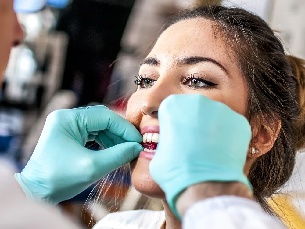 Имплантолог проверяет установку виниров